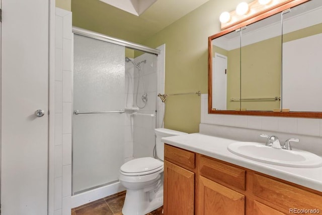 bathroom featuring a shower with shower door, backsplash, vanity, toilet, and tile patterned floors