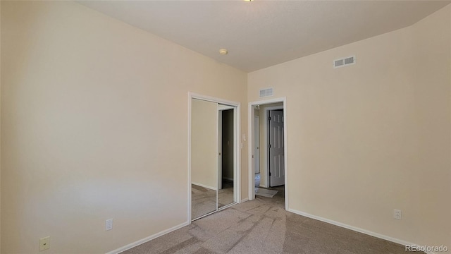 carpeted empty room featuring visible vents and baseboards