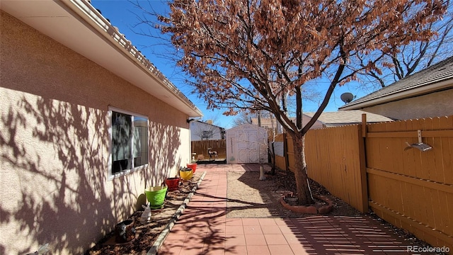 view of side of home featuring stucco siding, an outdoor structure, a patio area, a storage unit, and fence
