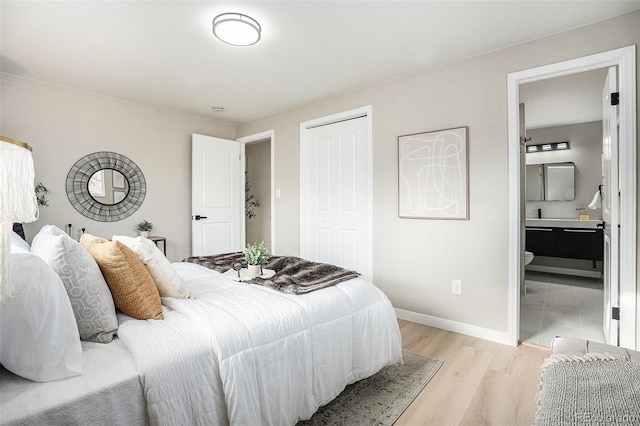 bedroom with ensuite bathroom and light hardwood / wood-style flooring