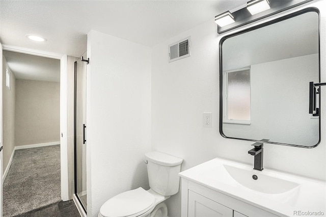 bathroom featuring vanity, toilet, and a shower with door