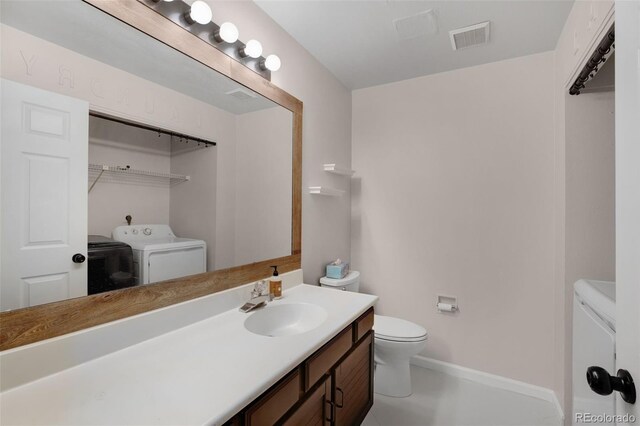 bathroom featuring baseboards, visible vents, toilet, independent washer and dryer, and vanity