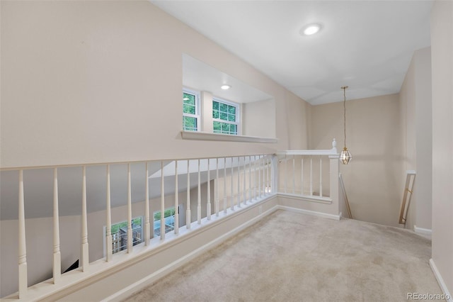 corridor featuring carpet floors and an upstairs landing