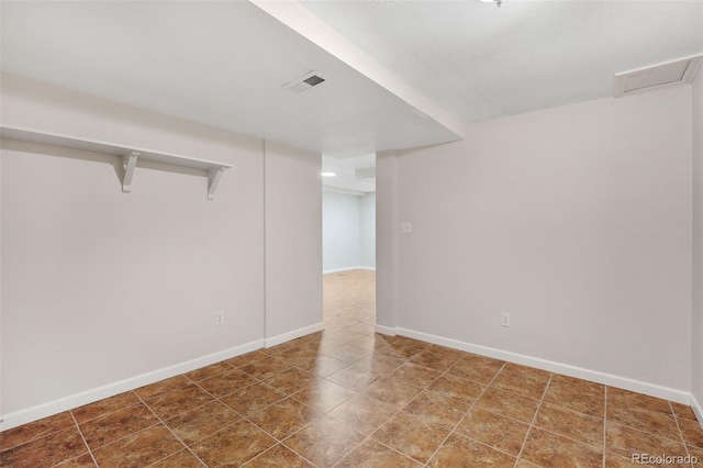 spare room featuring visible vents and baseboards