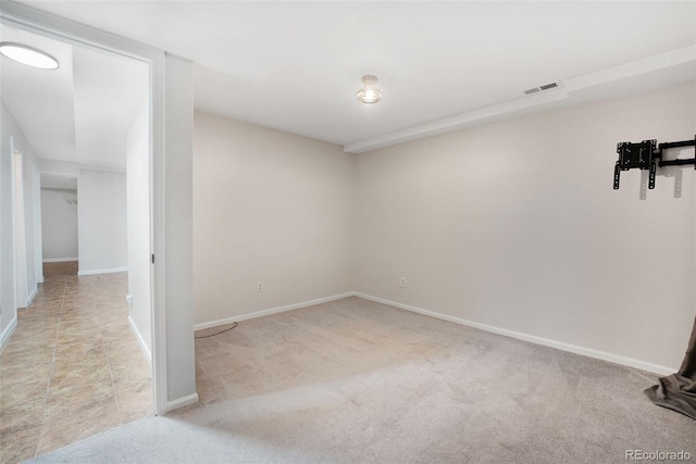 carpeted empty room featuring visible vents and baseboards