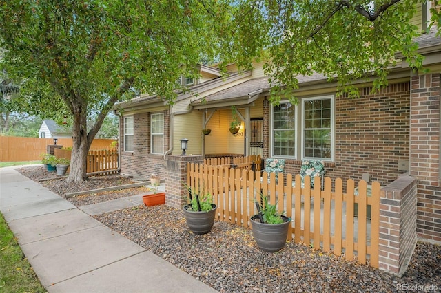 view of front facade featuring fence and brick siding