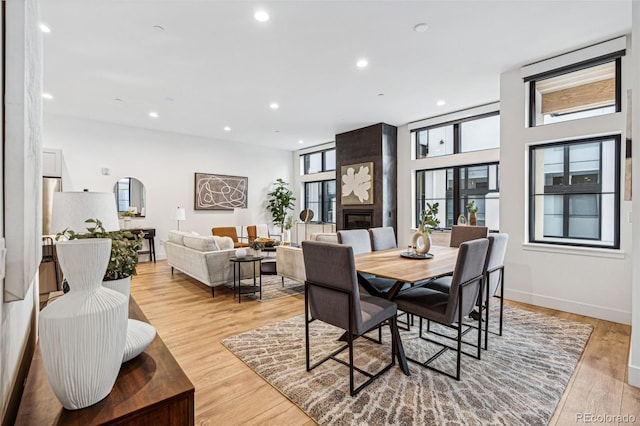 dining space with a fireplace and light hardwood / wood-style floors