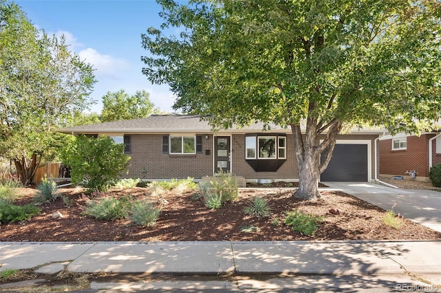 ranch-style house featuring driveway, brick siding, and an attached garage