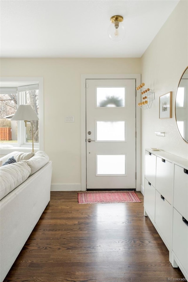 foyer with baseboards and dark wood finished floors