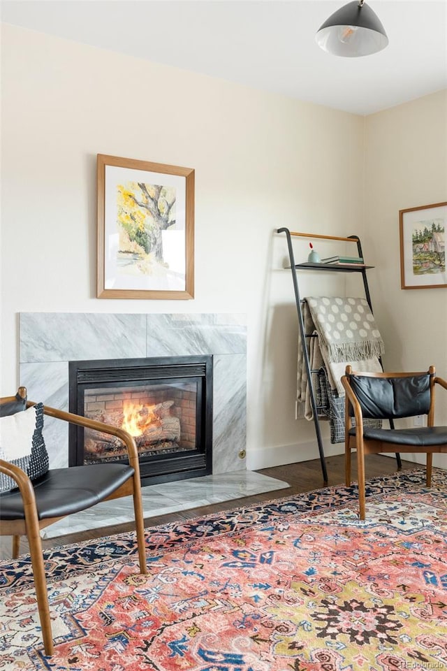 living area with a fireplace, baseboards, and wood finished floors