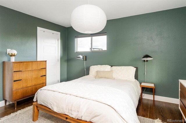 bedroom with wood finished floors and baseboards