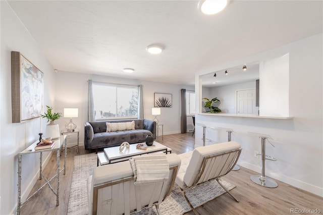 living room with baseboards and light wood finished floors