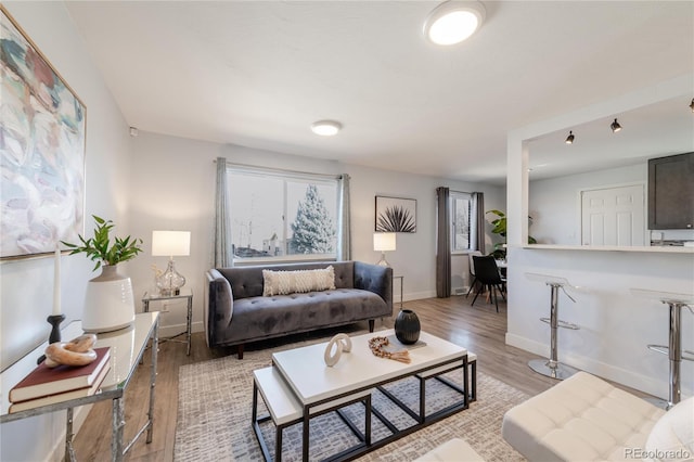 living area featuring light wood finished floors and baseboards