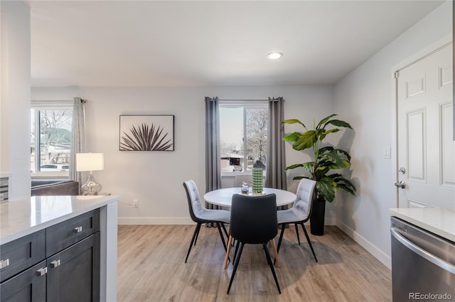 dining space with recessed lighting, baseboards, light wood-type flooring, and plenty of natural light