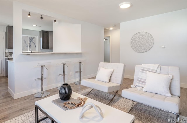 living room featuring baseboards, recessed lighting, and light wood-style floors