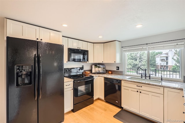 461 S Kalispell Way Unit D, Aurora, CO 80017 - kitchen featuring black appliances, light stone countertops, light wood finished floors, white cabinets, and recessed lighting