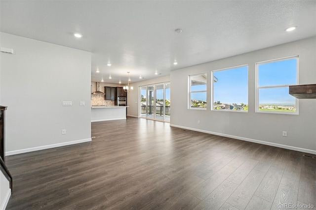 9374 Quartz St, Arvada, CO 80007 - unfurnished living room featuring baseboards, dark wood finished floors, a chandelier, and recessed lighting