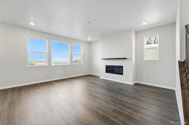 9374 Quartz St, Arvada, CO 80007 - unfurnished living room featuring a glass covered fireplace, dark wood finished floors, stairway, baseboards, and recessed lighting