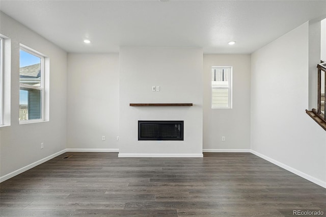 9374 Quartz St, Arvada, CO 80007 - unfurnished living room with dark wood-style floors, a glass covered fireplace, recessed lighting, and baseboards