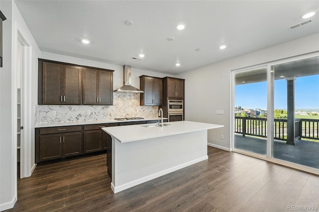 9374 Quartz St, Arvada, CO 80007 - kitchen featuring wall chimney range hood, a sink, backsplash, dark wood finished floors, and recessed lighting