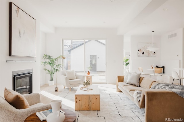 living room featuring visible vents and a glass covered fireplace