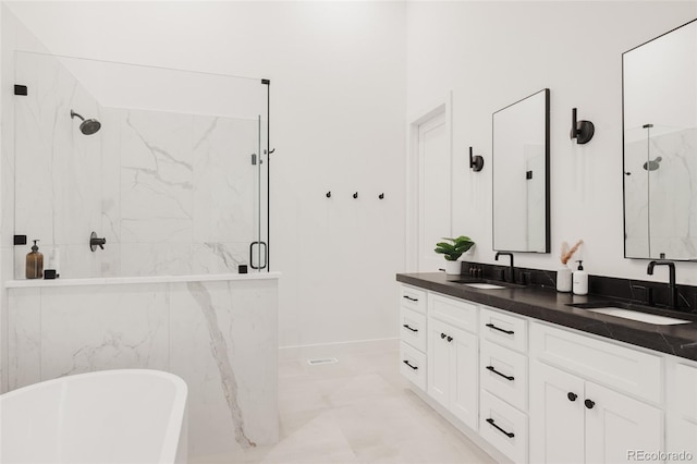 bathroom featuring a sink, a marble finish shower, double vanity, and a freestanding tub