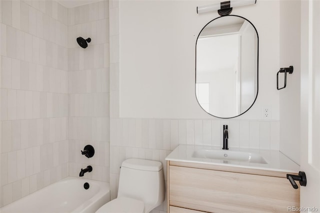 full bath with vanity, a wainscoted wall, shower / tub combination, toilet, and tile walls