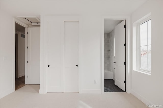 unfurnished bedroom with baseboards, visible vents, a closet, carpet flooring, and connected bathroom