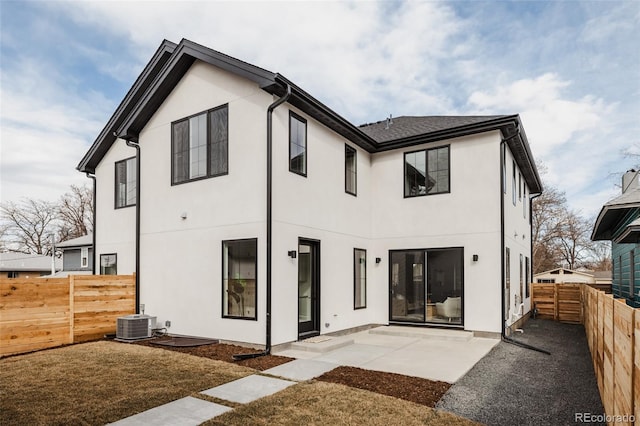 rear view of house featuring a fenced backyard, stucco siding, central AC, and a patio