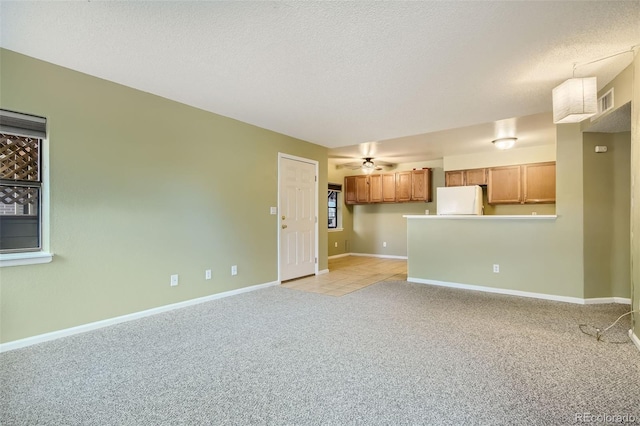 unfurnished living room featuring ceiling fan, light carpet, and a textured ceiling