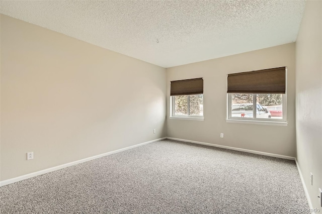 carpeted empty room featuring a textured ceiling