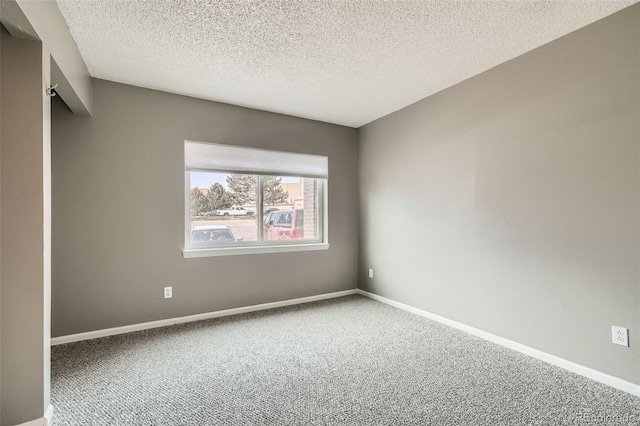 empty room featuring carpet and a textured ceiling