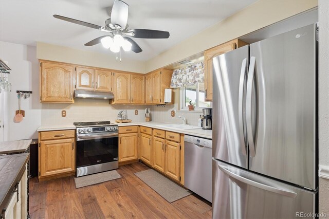 1774 S Dover Way, Lakewood, CO 80232 - kitchen with stainless steel appliances, under cabinet range hood, wood finished floors, ceiling fan, and backsplash