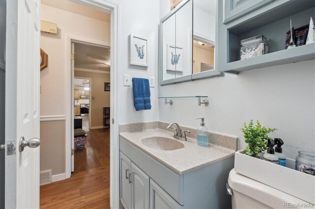 1774 S Dover Way, Lakewood, CO 80232 - bathroom with wood finished floors, vanity, and ornamental molding