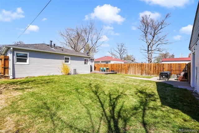 view of yard with a patio, a fenced backyard, and central AC