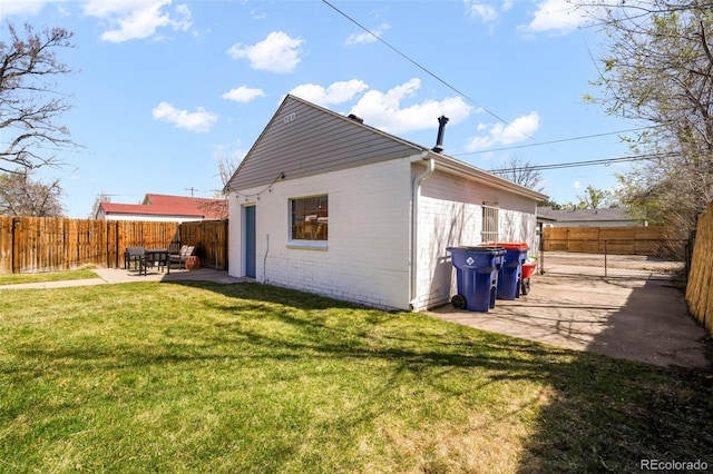 rear view of property with a lawn, a patio area, and a fenced backyard