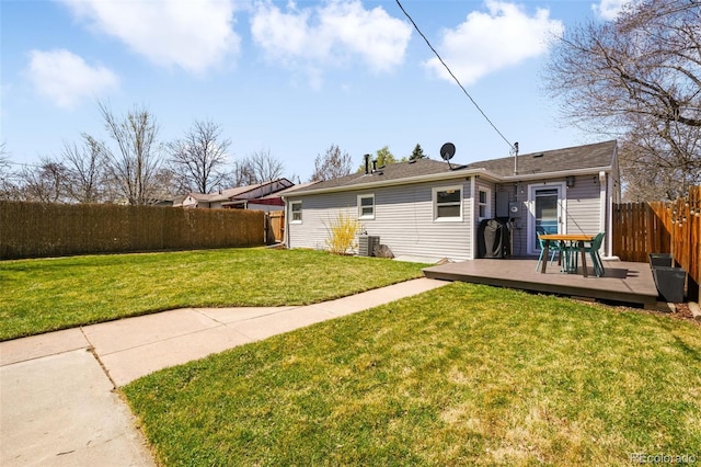 back of house featuring a lawn, a wooden deck, and fence