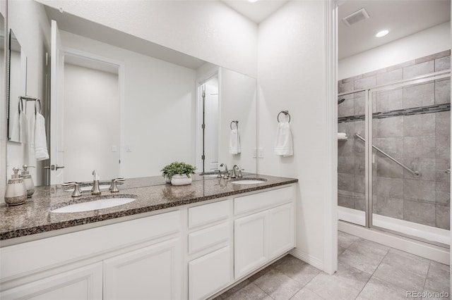 10387 Harrisburg St, Parker, CO 80134 - bathroom featuring double vanity, a stall shower, tile patterned flooring, and recessed lighting