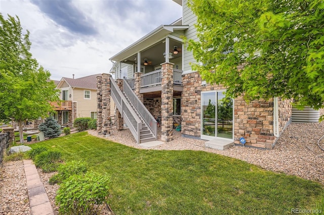 23503 E Minnow Dr, Aurora, CO 80016 - rear view of house with ceiling fan, a yard, stone siding, and stairs