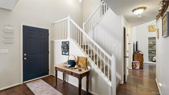 foyer entrance with dark hardwood / wood-style flooring and a textured ceiling