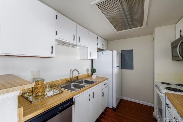 kitchen with appliances with stainless steel finishes, white cabinetry, dark wood-type flooring, and sink