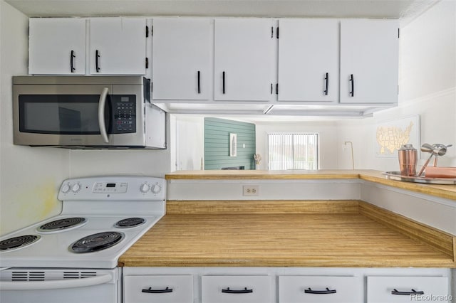 kitchen featuring white range with electric stovetop and white cabinetry