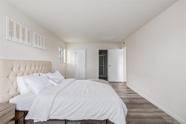 bedroom with dark wood-type flooring and a textured ceiling