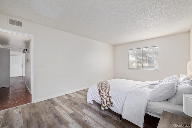 bedroom featuring hardwood / wood-style floors and a textured ceiling