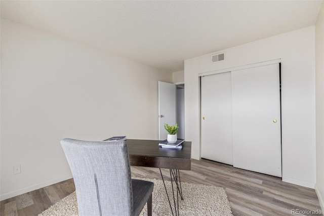 home office featuring a textured ceiling and light wood-type flooring