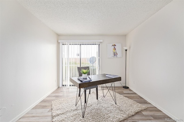 office area featuring a textured ceiling and light hardwood / wood-style flooring