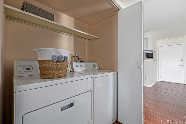 clothes washing area with hardwood / wood-style floors and independent washer and dryer