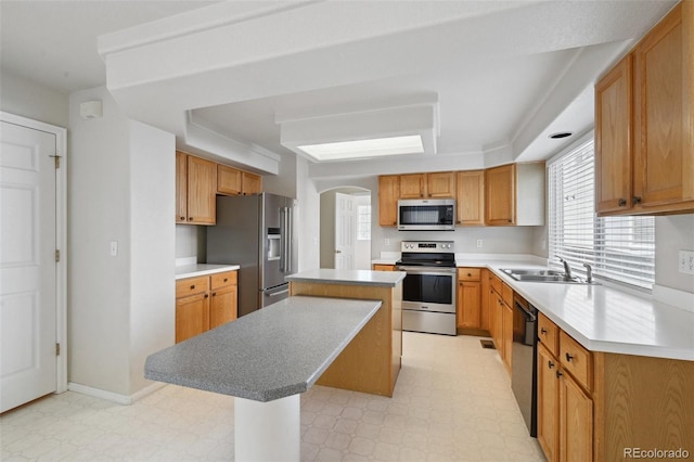 1272 Braewood Ave, Highlands Ranch, CO 80129 - kitchen featuring stainless steel appliances, a center island, light floors, a sink, and arched walkways