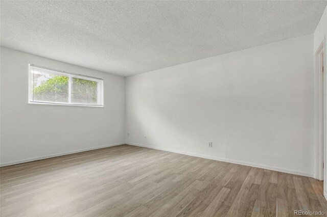 7755 E Quincy Ave Unit 107D2, Denver, CO 80237 - empty room featuring wood finished floors, a textured ceiling, and baseboards