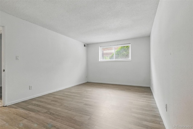7755 E Quincy Ave Unit 107D2, Denver, CO 80237 - unfurnished room featuring wood finished floors, a textured ceiling, and baseboards